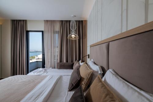 a bedroom with a large bed and a large window at Gloria Palace Hotel & SPA in Golem