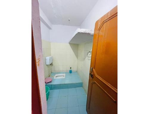 a small bathroom with a toilet in the floor at Hotel Maharishi, Uttarkashi in Uttarkāshi