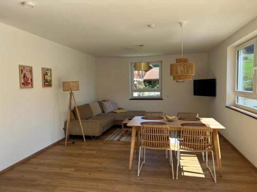 Ferienwohnungen Rössle في Stiefenhofen: غرفة معيشة مع طاولة وكراسي وأريكة