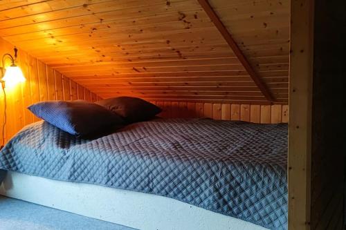 1 cama en una cabaña con techo de madera en Stuga Koppekull Långasjö, en Långasjö
