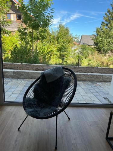 a black chair with a blanket sitting on a porch at Ferienwohnungen Rössle in Stiefenhofen