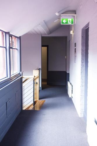 an empty hallway in an office building with a exit sign at Central Hotel Hobart in Hobart
