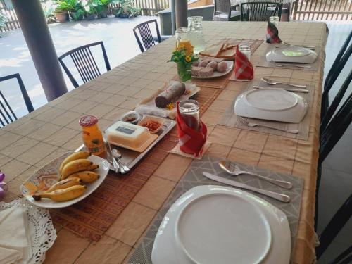 a table with plates of food on top at Nature's Hideout Holiday Home in Mirigama