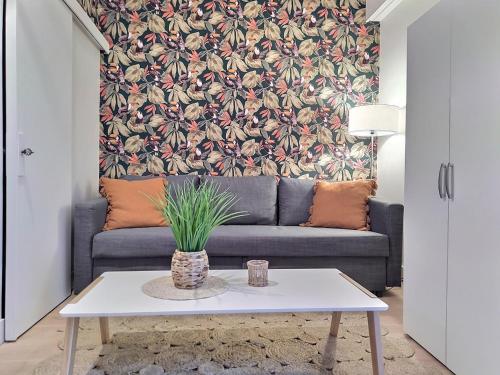uma sala de estar com um sofá e uma mesa em Cosy Break Jardins des plantes em Le Mans