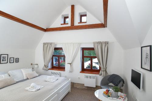 Bílá TřemešnáにあるPenzion Štěrbova vilaの白いベッドルーム(ベッド1台、ソファ付)