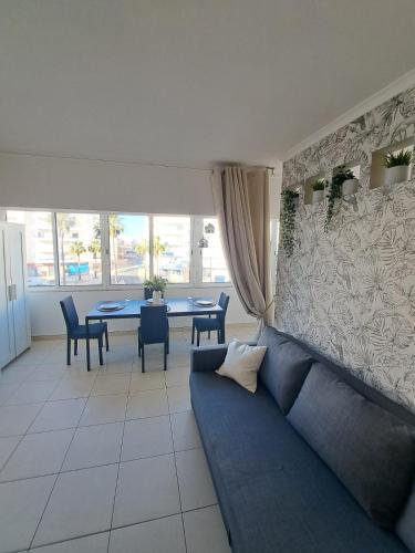 a living room with a blue couch and a table at T1, proche plage et commerces in Quarteira