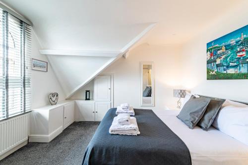 a white bedroom with a bed and a large window at Greyfriars in Clacton-on-Sea