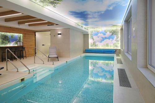 a swimming pool with a mural of clouds at Penzión Solisko*** Oščadnica in Oščadnica