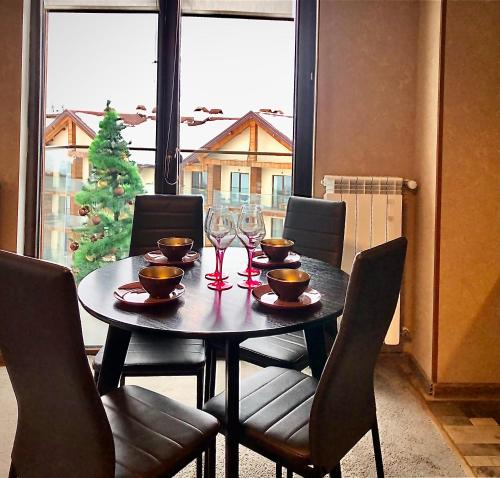 una mesa de comedor con copas de vino y sillas en 2-room Apartment NFT New Gudauri 505 en Gudauri