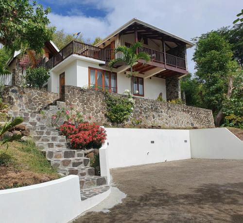 uma casa com uma parede de pedra e uma cerca branca em Harbour View House em Port Elizabeth