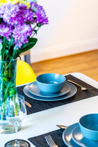 a table with two bowls and a vase of purple flowers at Greyfriars in Clacton-on-Sea