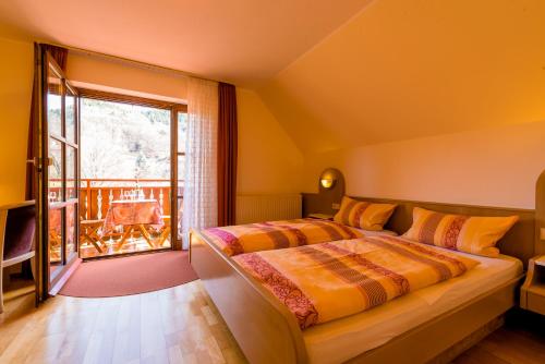 a bedroom with two beds and a balcony at Gästehaus Sonne in Gernsbach