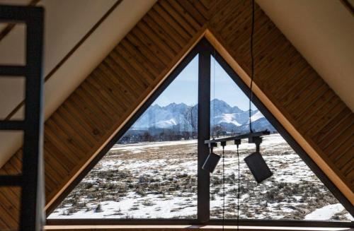 ventana del ático con vistas a una montaña nevada en Stodoła na polanie, en Poronin