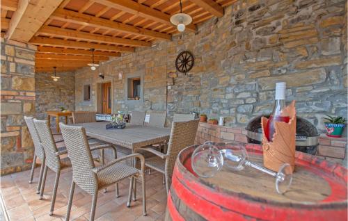 uma sala de jantar com mesa e cadeiras e uma parede de pedra em Beautiful Home In Smarje With House A Panoramic View em Šmarje