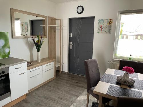 a kitchen and dining room with a table and a door at Garzer Ruhepol in Garz-Usedom