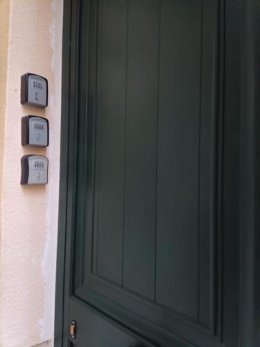 a green door with clocks on a wall at Aspra al delfino blu in Bagheria