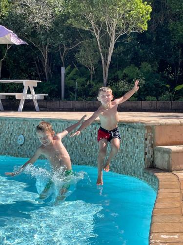 two young boys jumping into a swimming pool at 75 The Dunes in Plettenberg Bay