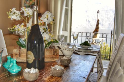 a bottle of wine sitting on a wooden table at Spiaggia Amore - Appartamenti Vacanza Vista Lago - Luxury Apartments in Cannobio