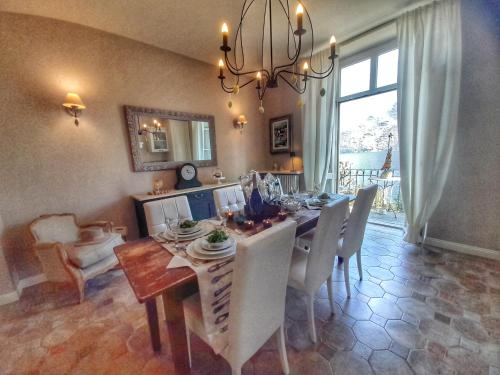 ein Esszimmer mit einem Tisch, Stühlen und einem Kronleuchter in der Unterkunft Spiaggia Amore - Appartamenti Vacanza Vista Lago in Cannobio
