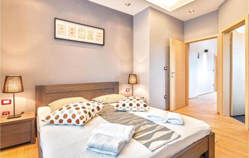a bedroom with a large bed with two pillows at 4 Bedroom Awesome Home In Trosti in Heki