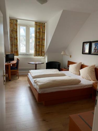 een slaapkamer met een bed, een bureau en een raam bij Vier Jahreszeiten in Heidelberg