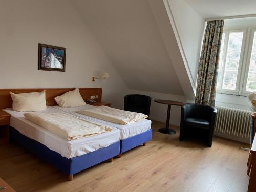 een slaapkamer met een bed, een tafel en een raam bij Vier Jahreszeiten in Heidelberg