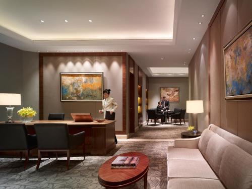 a hotel lobby with a woman standing in the middle at Shangri-La Manzhouli in Manzhouli