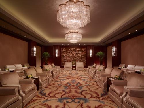 a large waiting room with chairs and a chandelier at Shangri-La Manzhouli in Manzhouli