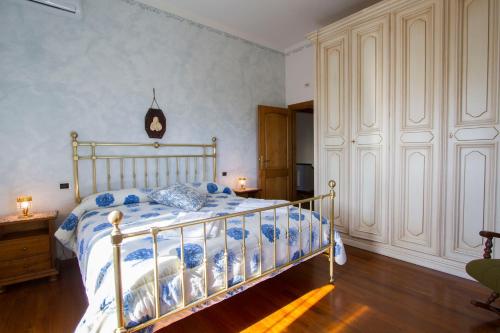 1 dormitorio con 1 cama con edredón azul y blanco en Casa Pupa- Azienda Fontelunga, en Cortona