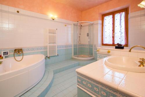 y baño con bañera, lavamanos y ducha. en Casa Pupa- Azienda Fontelunga, en Cortona