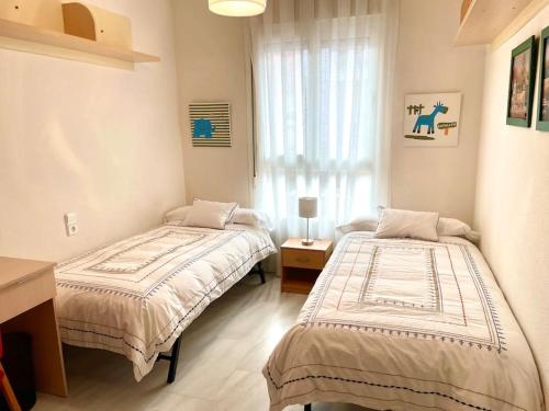 1 dormitorio con 2 camas y ventana en Apartamento Zoco Córdoba en Córdoba