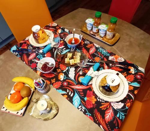 a table with a breakfast of fruit and juice at Au Mange-Prunes in Auzon