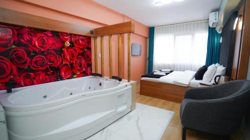 Lukka Suit Hotel في إسطنبول: حمام مع حوض استحمام مع ورود حمراء على الحائط