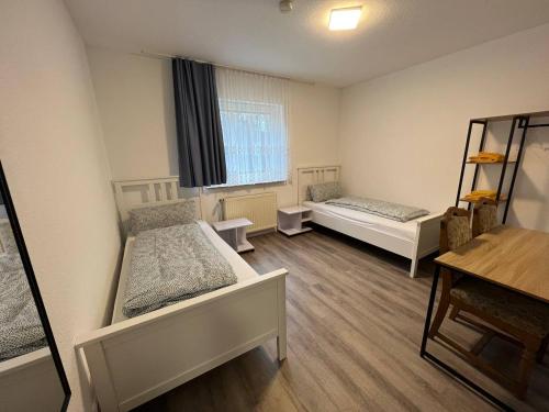 a room with two beds and a window at Dill Apartments Peine in Peine