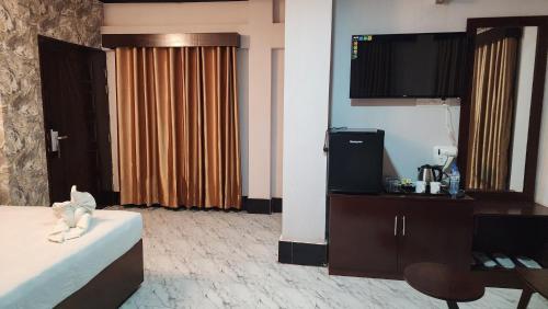 pokój hotelowy z łóżkiem i telewizorem z płaskim ekranem w obiekcie Sunset Bay Hotel w mieście Koks Badźar