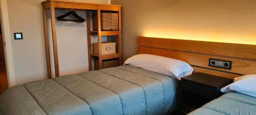 a bedroom with two beds and a book shelf at Alojamientos Viveiro - El Escairo in Viveiro