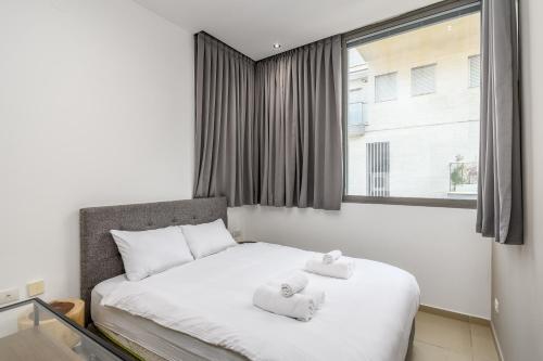 una camera da letto con un letto e due asciugamani di New branded APT by Sea u TLV a Tel Aviv