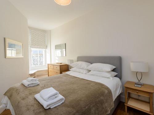 um quarto com uma cama grande e toalhas em By The Sea em North Berwick