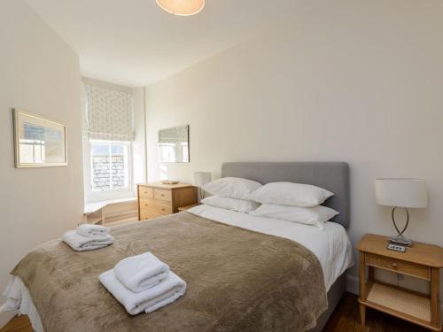 a bedroom with a large bed with towels on it at By The Sea in North Berwick