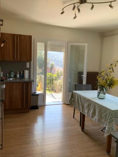 une cuisine avec une table recouverte d'une nappe dans l'établissement Villa des taillades, à Le Collet-de-Dèze