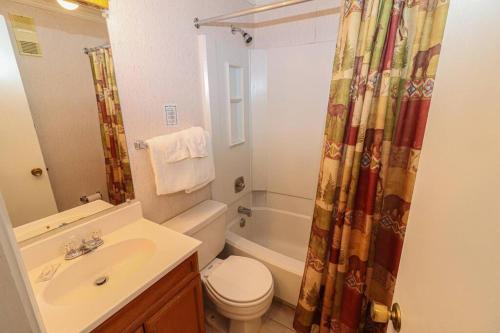 a bathroom with a toilet sink and a shower curtain at ML328A 1BR Quiet corner unit! Close to Ballhooter in Snowshoe