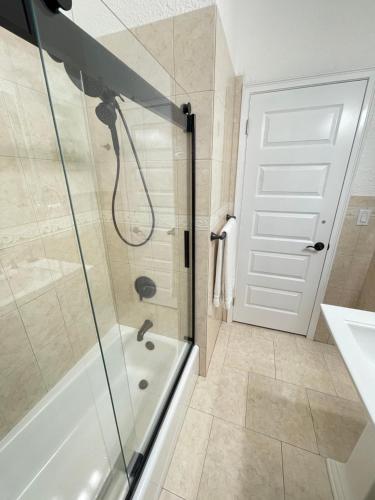 a bathroom with a shower and a tub and a sink at Crest Lake Beach House in Clearwater