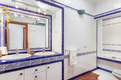 a bathroom with two sinks and a mirror at Villa Cala Xuclar in Portinatx
