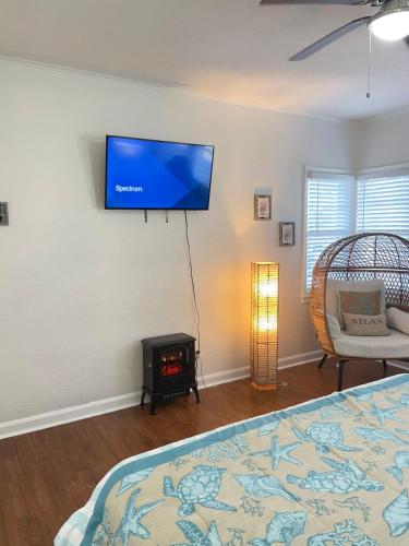 a bedroom with a bed and a flat screen tv on the wall at Crest Lake Beach House in Clearwater