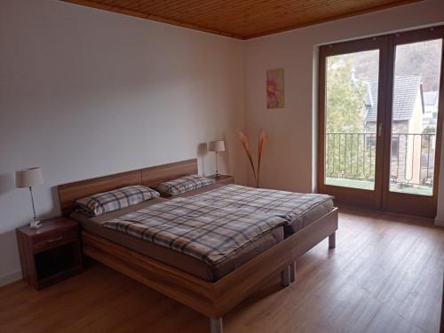 a bedroom with a bed and a large window at Adenauer Cottage in Adenau
