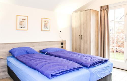 Cette chambre comprend un lit avec des oreillers violets et une fenêtre. dans l'établissement Nice Home In Hoge Hexel With Kitchen, à Hoge-Hexel