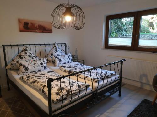 1 dormitorio con 2 camas, ventana y lámpara de araña en Ferienwohnung „Kersten“, en Bereborn
