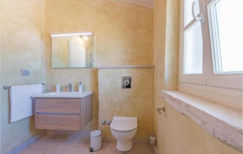 a bathroom with a toilet and a sink and a window at 5 Bedroom Cozy Home In Vodnjan in Vodnjan