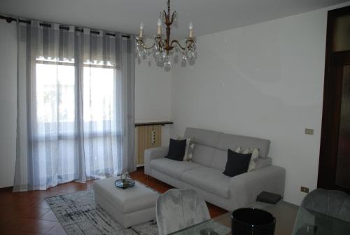 uma sala de estar com um sofá e um lustre em Appartamento Vera em Ponte San Nicolo