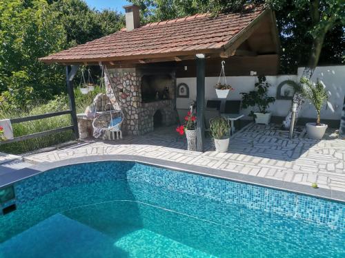 a swimming pool in front of a house with a gazebo at Apartment holidays and partys with a pool in Tuzla